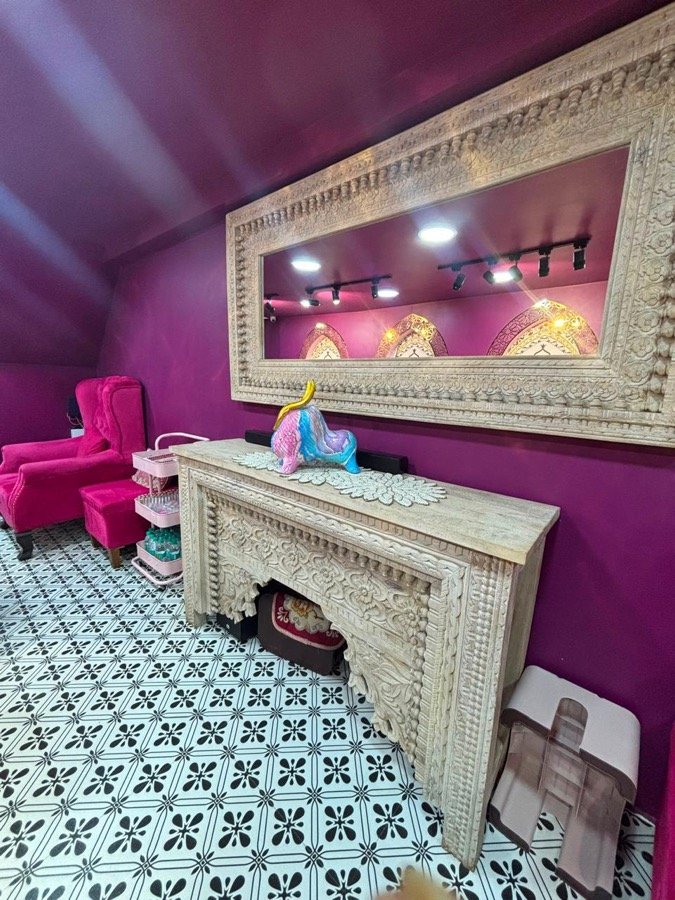 Carved wooden mirror and mantel in the magenta salon