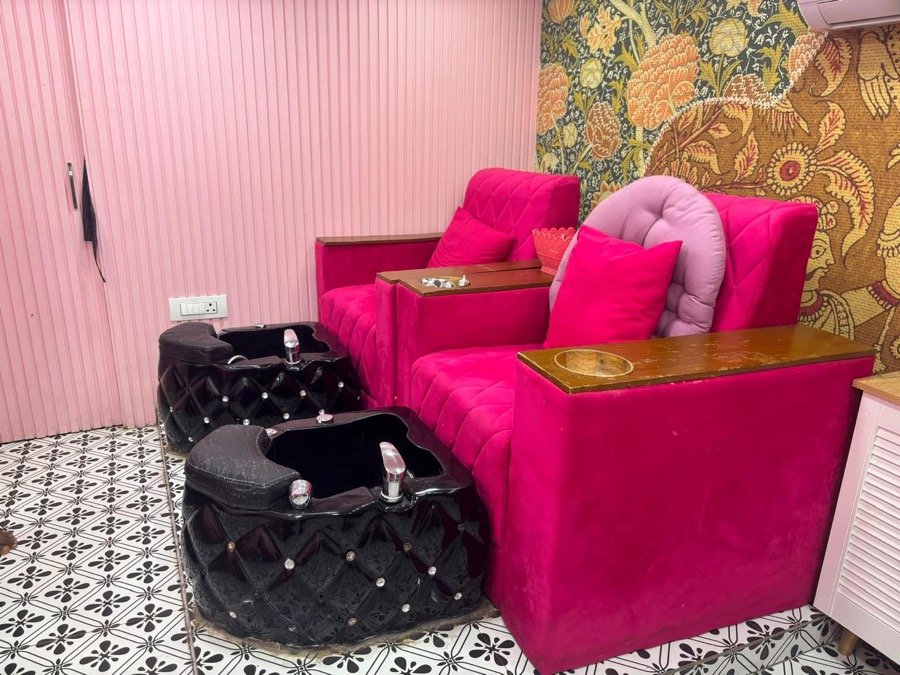 Hot-pink velvet pedicure stations with floral wallpaper