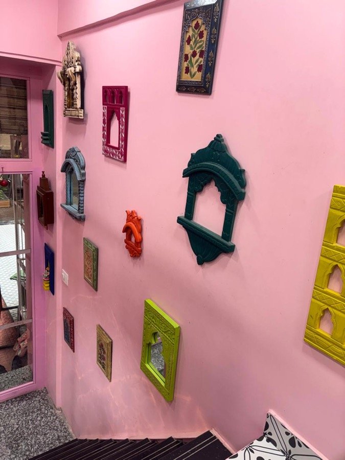 Pink wall with colourful hand-carved Rajasthani frames