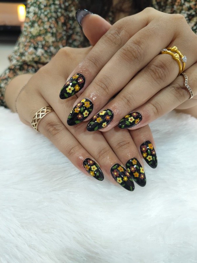 Black nails with gold and floral hand-painted nail art